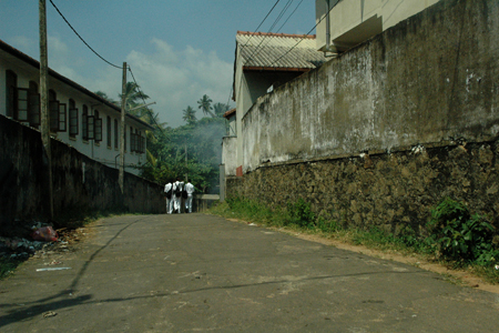 Three students, wearing their backpacks, go up the hill to class at St. Aloysius College.