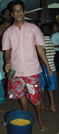 Mr. Prasad and a large plastic bucket of fruit salad