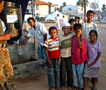 Some camp children in front of the water donated from Pakistan